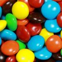 A pile of multi-colored candies with hard shell coatings.